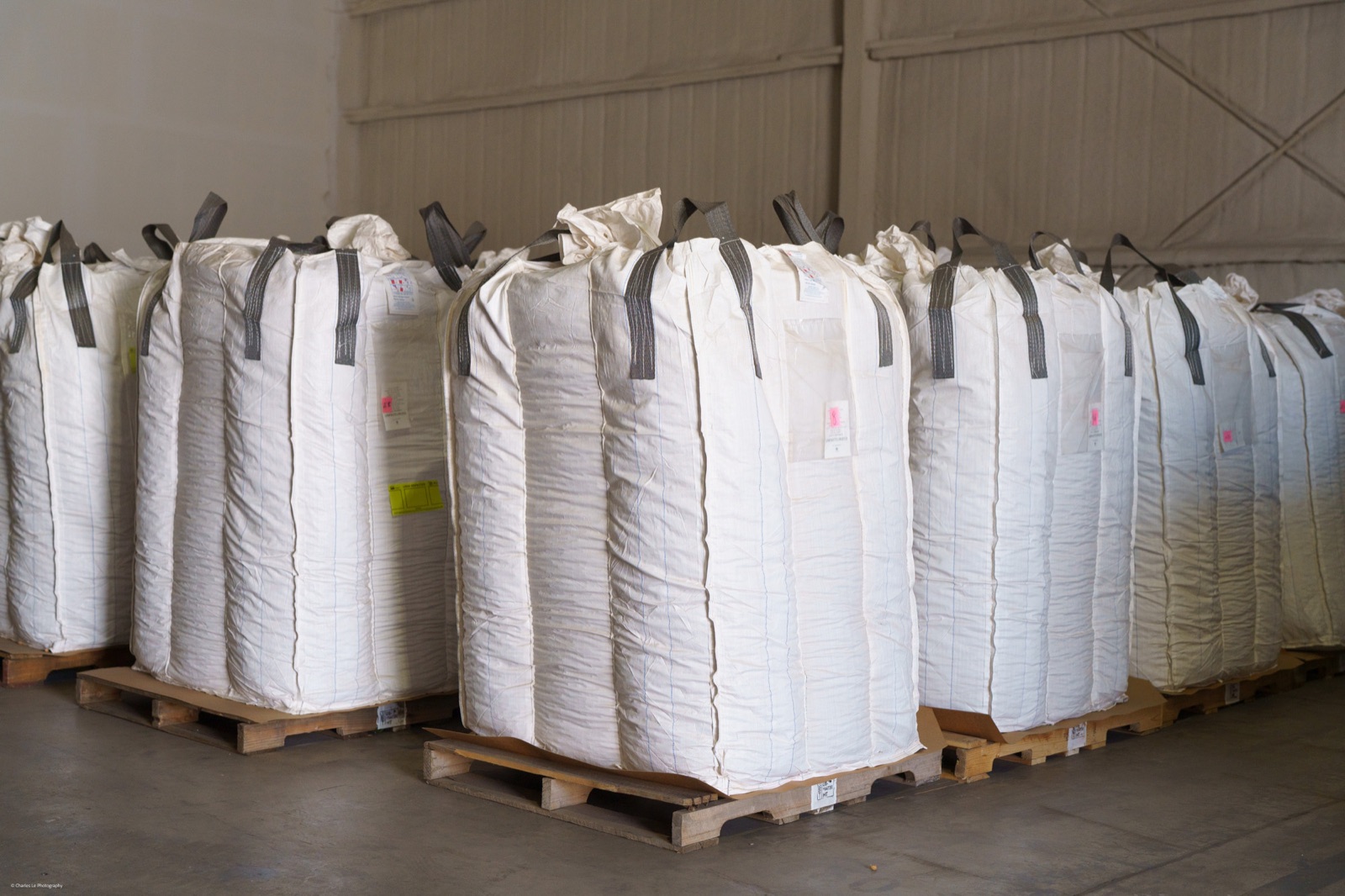 Bulk almond totes staged on pallets inside a warehouse